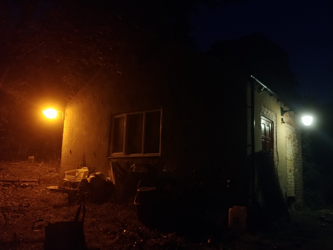 The 2 lanterns lit on the shed at night
