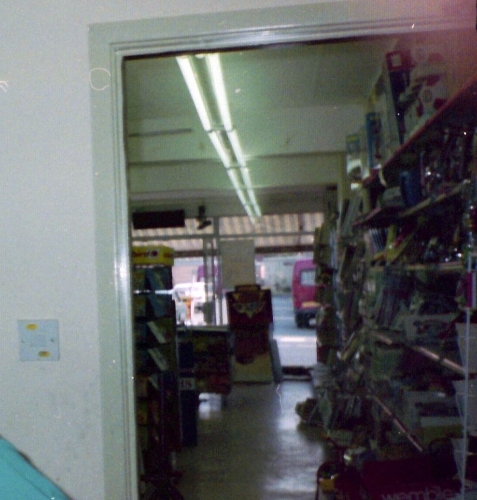 8ft Thorn Pop Packs
This photo was taken in Summer 1990 in the newsagents where I was a paper boy and shows the 8ft Thorn PP twins that lit the main shop. This shot is looking through from the news paper depot where we prepared the 18 paper rounds from a computer print out. At this time we had just moved from the separate depot across the road where I got that lovely GEC fitting. If you look carefully to the front of the shop you can just make out the reflective strips on a skip which is where that GEC fitting would have ended up if I had not rescued it.

You can get some idea of how high the illumination level is in the shop as this shot was taken on a fixed shutter speed camera with 100 ISO 35mm film. 100 ISO film was designed for outdoors or use with a flash, being 1990 it was to be a few more years before digital cameras were available to consumers.
