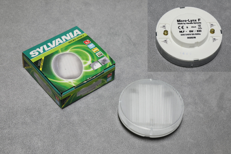 6w Sylvania MicroLynx F
1 x 6w Sylvania Microlynx F compact fluorescent lamp.

These ultra low profile lamps were originally developed to replace tungsten halogen lamps used in furniture & cabinet lighting and other applications where a compact low temperature light source was required.

Inside these little lamps is a small diameter fluorescent tube that has been formed into a flat grid behind a prismatic cover.
The very compact electronic ballast is in the lamp base behind a metal disc that acts as both a reflector and heat shield.

You can read a very interesting brochure here:
[url]http://www.lamptech.co.uk/Documents/Brochures/Sylvania%20-%20Brochure%20-%20FLCi%20-%20MicroLynx%20F%20-%202005%20EU.pdf[/url]
