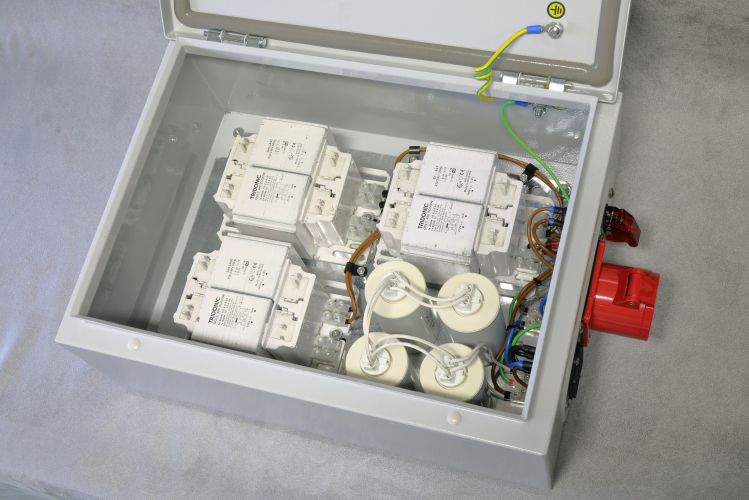 DIY 1000w Compact Source Iodide Gearbox: Internals.
Showing the inside of the Hylec DEDS0400 steel IP66 enclosure which houses the gear required to run 1 x 1000w CSI PAR64 lamp.

It consists of 3 x 400w Australian-made Tridonic chokes wired in parallel and 4 x 50uf 250v PFC capacitors also wired in parallel.
There is a non-latching toggle switch which triggers the high-voltage pulse transformer which is located inside the actual luminaire.
I was tempted to add a mechanical timer which applies power to the ignitor for 3 seconds when power is first applied but I went with manual ignition in the end.
All wired with nice tri-rated cable with ferrules on any conductor which goes into a screw terminal and I have soldered as well as crimped any spade & ring terminals... because I can.

The whole thing is quite heavy and turned out to be quite expensive... but worth it.
I wonder when the last time a 1kW CSI gearbox was commissioned? :) 
