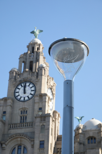 Philips Metronomis "Custom Liverpool" LED Lanterns.
The Philips Metronomis LED lanterns which light up the area of the Pier Head in front of the "Three graces*" in Liverpool have been customised with a transparent sheet of plastic which bears an image of the famous Liver Bird, a Cormorant which is the symbol of the city.
When lit up at night the effect is quite nice!

Pictured in the background are two more Liver birds atop of the Royal Liver building. Legend has it that the bird at the front is female and is looking out to sea for the safe return of the seamen while the bird at the back looking into the city is watching over their families.
What is more commonly told is that the male bird looking inland is waiting for the pubs to open :)

* The Three Graces are the famous trio of listed buildings on the Liverpool waterfront which includes the Royal Liver Building, the Cunard buildings and the Mersey Docks and Harbour company building.

