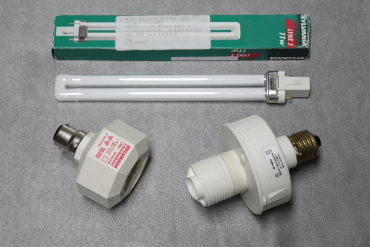 PL-S Adapters: Sylvania vs Smart & Brown.
One "West German" (so pre 1990) Sylvania Lynx-Diamant LXDA 511S/240 vs a UK made S&B DP 188014 adapter for 1 x 5/7/9 or 11w PL-S lamps.

The Sylvania is the clear winner here due to its compact length. Even the lower wattage PL-S lamps are quite long and when fitted to an adapter the lamp tends to protrude from any shade quite a lot, especially the S&B one. An 11w lamp is pictured for scale (The Sylvania comes c/w an 11w).
Its interesting to note how the E27 base on the S&B sticks out so much and instead of the PL-S socket being recessed like on the Sylvania model, the S&B has it sticking out with threads on as if it was to be used with an adapter to fix a shade or some other reflector directly to the adapter.

Both of these are really best used with a 9w or lower lamp because of the excessive length...
