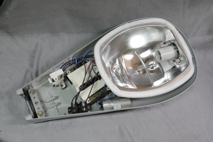 GE M250R2 200w SON: Internals
Showing the gear of this US lantern.
Has a honking great autotransformer type ballast and is designed for 480v 60hz supply voltage.
That glass prismatic blow is almost half the weight of the lantern and I'll show a closer pic of it.
The high supply voltage doesn't matter as I'll be replacing all the gear with either 150w or 250w European SON gear.
Probably the only thing that will get retained is the 280v 25uf capacitor!
This is NOS from 2004.
