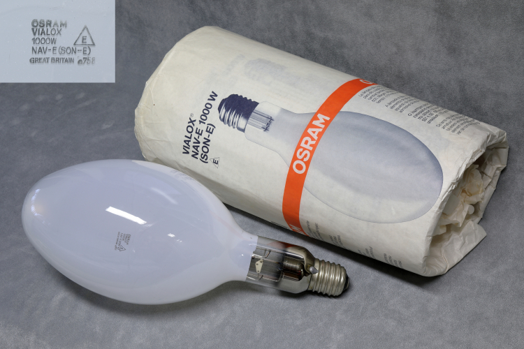 1000w Osram VIALOX NAV-E
1 x 1000w Osram Vialox coated elliptical high-pressure sodium lamp. NOS. UK-Made.

Quite a fearsome looking thing that seems to share it's outer envelope with the 1kW MBF lamp.
It's will be interesting to put one of these head to head with a 1000w mercury as this is almost twice the lumens!

It has an interesting construction. There is a double support frame which crosses over in the middle of the lamp.
