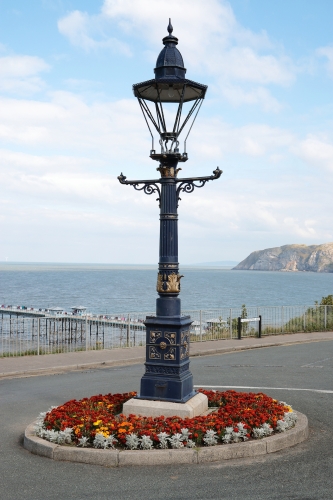 Sugg Westminster
Ex-gas Sugg Westminster that dates from the 1890's located along Alex Munro Way in Llandudno, Wales.

Was converted at some point to discharge and appears to now burn a 150w SON lamp.

Appears to have lost it's glazing at some point due to vandalism or bad weather since this is in an exposed location.

Was refurbished in 1985 by the manufacturer.
