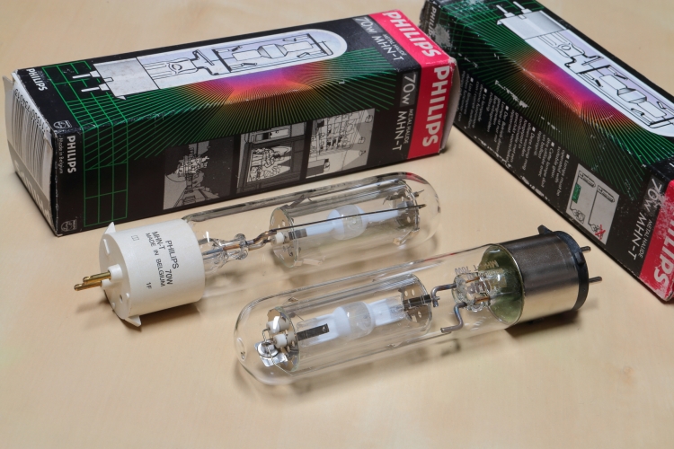 Philips 70w MHN-T
Two protected quartz metal halide lamps with PG12-2 caps. The early lamps (along with the SDW-T) featured a while plastic base but this was changed to metal on the later lamps because the plastic tended to discolour when in use.

 An interesting lamp as it uses thulium, dysprosium and holmium iodides in the discharge mixture. Thulium is quite an aggressive halide and this would sometimes lead to arc tube explosions so two thick quartz shields were employed to allow safe operation.

 The prefocused PG12-2 cap was selected to ensure excellent optical control when the small arc gap was positioned at the focal point of a reflector.

