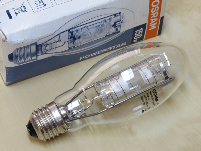 Osram Powerstar HQI-E 150w Clear
150w cool white quartz metal halide lamp with a clear elliptical outer envelope.
Protected arc tube rated for use in open or closed luminaires.
Quite a substantial shield going on there.

6000h
11500lm
4000k 
