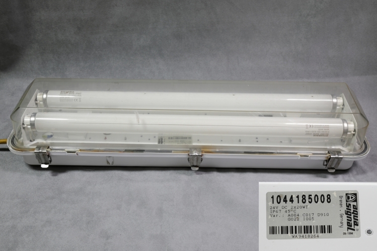 Aqua-Signal 1044 2 x 20w 24vDC bulkhead 
1 x Aqua-Signal 1044 marine fluorescent luminaire for 2 x 20w lamps.
These are incredibly robust IP67 fittings and can be found on ships all over the world.
They are available in a variety of control gear such as 240 and 110v AC in switch-start and HF. They are also, like this one, available in 24vDC.
The luminaire body is available in either 316 stainless or zinc plated steel. 

eBay win for Â£11!!! I bet they are quite a bit more than that when new!

MFD September 1994

