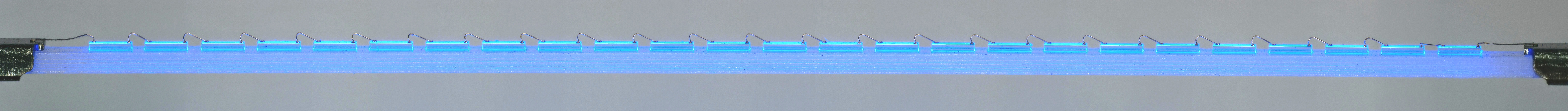 LED Filament without phosphor
This photo from a microscope shows the internal construction of an LED filament before application of its phosphor coating.  In this particular filament (length 38mm) there are 25x 450nm blue-emitting die affixed to a strip of transparent sapphire, and interconnected in series with gold wires.
Keywords: LED Filament