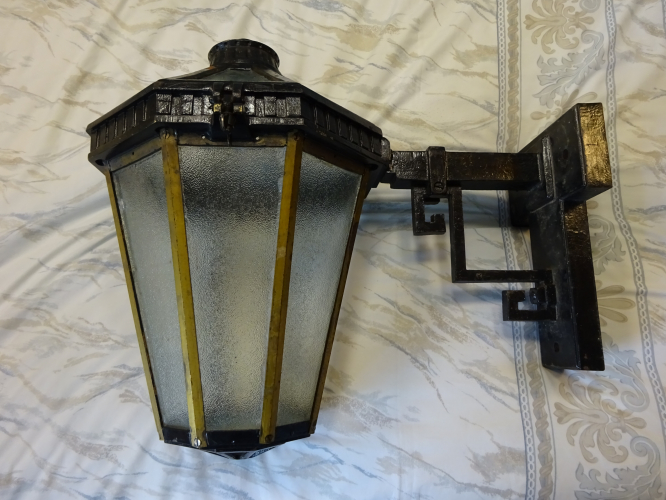 Revo B9504
Bought recently from an antique fair is this absolutely stunning Revo B9504 lantern, in actually really clean and good overall condition. I didn't even have to haggle, the seller knocked themselves down by nearly half to a more than reasonable price, hence I bit and ran! One thing I cannot understate is how god damned HEAVY the lantern is, I had to stop and rest about seven times as I took it back to the car. That's because the whole light is constructed entirely out of Cast Iron, the framework being Brass. Add the glass, its no wonder its so heavy!

Its been given a restoration, and while most of it overall is good, its only when you open it where the work goes south, as the glasswork is nothing more than a bodge to my eyes. All the brass clamps that hold the glass in place have been removed, the glass itself having been poorly siliconed in place. One pane of glass is also mismatched, and the one at the very bottom isn't even big enough to seal the lantern. 
The lamp holder and mounting bracket have also been removed. Considering this lantern is intended to run 300w GLS, means finding a matching bracket for the lamp holder will be very difficult. I'm currently in the process of having a new bracket made however, so soon should be sporting a 300w GLS lamp as intended from new

Since these photo's were taken, I've stripped all the glass out and had all new matching glass cut to size, ready to fit. I've also located original brass 4BA and 3/16" whit screws, and hopefully with dads help some correct 0.75mm gauge brass sheet in which I can cut and bend into new glass clips. I intend to strip the paint off and respray it back to it original dark green colour, polish and clear lacquer the brass uprights on the frame, and add some gold highlights to the upper rim and the cast top piece, as well as the scrollwork. Hopefully this will warrant me being allowed to install it somewhere, its far too nice to leave uninstalled imo (plus its weight makes it an absolute pain....)
