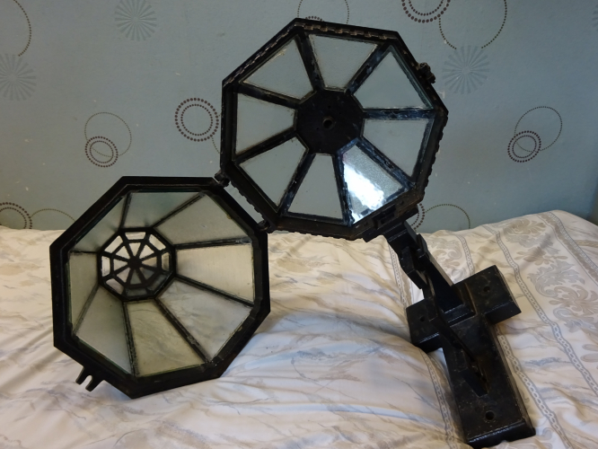 Revo B9504 internals
Bought recently from an antique fair is this absolutely stunning Revo B9504 lantern, in actually really clean and good overall condition. I didn't even have to haggle, the seller knocked themselves down by nearly half to a more than reasonable price, hence I bit and ran! One thing I cannot understate is how god damned HEAVY the lantern is, I had to stop and rest about seven times as I took it back to the car. That's because the whole light is constructed entirely out of Cast Iron, the framework being Brass. Add the glass, its no wonder its so heavy!

Its been given a restoration, and while most of it overall is good, its only when you open it where the work goes south, as the glasswork is nothing more than a bodge to my eyes. All the brass clamps that hold the glass in place have been removed, the glass itself having been poorly siliconed in place. One pane of glass is also mismatched, and the one at the very bottom isn't even big enough to seal the lantern. 
The lamp holder and mounting bracket have also been removed. Considering this lantern is intended to run 300w GLS, means finding a matching bracket for the lamp holder will be very difficult. I'm currently in the process of having a new bracket made however, so soon should be sporting a 300w GLS lamp as intended from new

Since these photo's were taken, I've stripped all the glass out and had all new matching glass cut to size, ready to fit. I've also located original brass 4BA and 3/16" whit screws, and hopefully with dads help some correct 0.75mm gauge brass sheet in which I can cut and bend into new glass clips. I intend to strip the paint off and respray it back to it original dark green colour, polish and clear lacquer the brass uprights on the frame, and add some gold highlights to the upper rim and the cast top piece, as well as the scrollwork. Hopefully this will warrant me being allowed to install it somewhere, its far too nice to leave uninstalled imo (plus its weight makes it an absolute pain....)
