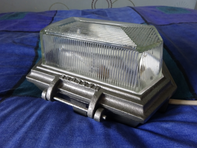 Maxlume Verity.
Bought earlier in the year, this Maxlume Verity was a very nice and unusually cheap find on eBay. All that was up with it was the glass was loose and it had surface rust all over. I asked the seller to remove the glass from the base, pack both in separate boxes, and then pack those in a larger outer box. What they done instead was wrapped the whole bulkhead in 3 layers of bubble wrap, taped shut in a plastic bag, and then it was put in a box full of air bags. When it turned up only 3 of those air bags actually had any air in them at all, but through some miracle, the bulkhead remained intact.

Incredibly some original paint remined inside the bulkhead, allowing me to identify the original colour as being hammered grey. Stripped down and rust treated, I was able to return the bulkhead back to its original colour. Sealing the glass in place, I attached some flex and the bulkhead sprang into life once again. Its an absolutely stunning 30's art deco style, and will be installed in place of one of my more shitty bulkheads in my workshed.
