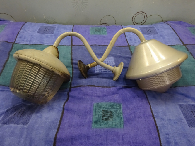 Coughtrie PW15 and Holophane Well glass lights before restoration
This Coughtrie PW15 and Holophane well glass light entered the collection in 2019 iirc, and both arrived in a well used, but overall good condition, a shocker for the PW15 cause they only have to have the slightest bit of damp on them and the screws seize solid. Upon arrival, the Coughtrie ran 125w MBF. I removed that and put it back to 2 pin BC, but from there it just ended up in storage in my lanterns shed, getting a bit battered from poor storage. The holophane however was pretty much restored immediately, but again ended up just being put away in storage.

It was very much a spur of the moment decision to strip down and restore them, mainly due to the fact I really like them and it was becoming criminal that I wasn't doing anything with them, the Holophane especially having already restored it once, and being an unusual design meant even just keeping it in storage was a waste.

Over the course of 2 weeks I stripped both of them down, which was a surprisingly easy task in regards to the PW15 owing to the screws seizing the minute they're screwed tight it seems. I carefully removed any corrosion and drilled out any screws where needed, before spraying both brackets and the exterior of the lights hammered grey, the insides going white as they should be. Sealing the glass back into place with silicone sealant proved to be an initially really messy, but overall satisfying job, and leaving the sealant overnight to cure resulted in a perfectly sealed light once again.

