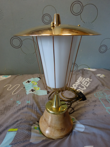 Falks GLS Pedestal light, after restoration.
Earlier this year I bought in this gorgeous Falks Pedestal light, which had been crudely 'upcycled' into a table lamp. Seeing past the mess to the potential it hid beneath the paint and dirt, I bought it and begun looking around for the parts that had been replaced or was missing.
 
First up was replacing the three hex nuts that should have been ball nuts. I managed to find some on eBay in an M4 thread, however they needed to be 4BA thread. I drilled the original thread out, retapped to M5, threadlocked the brass bolt in place, cut it flush and then drilled and tapped to 4BA. Part one done, the next and more complicated part was to find an original finial.

For this I needed to find a photo of one, and thanks to a fellow collector, was show an image of how it should look. This left me needing a piece of brass to turn and reshape, and that ended up showing itself in the most unusual of circumstances. Whilst digging around a column to move it while at work, a team mate hit some metal. It turned out to be an old brass lever, but with the almost perfect dimensions to become a new finial. I got it home, cut most of the bar off to allow me to put it in a drill. I cable tied the drill so it'd constantly spin, and with Dads help and his trusty flap disc in the angle grinder, turned the lever till it matched what I needed. I then cut the bar off completely before drilling and tapping into the now finial to 5/8" BSW. I got a brass bolt, washer and a rubber seal, and screwed the finial into place, really finishing off its 50's style beautifully. So that's the light completed again, the real restoration can now begin.

Polishing the light was actually fairly simple, the black paint on the base chipped off, and the 9 uprights were given to a neighbour to polish since he has a polishing wheel. Once the lid was polished, I painted the inside white, really smartening the whole thing up.
After much debating, I decided to keep it as a table lamp, its too nice to put outside again imo. So the wooden base was given to a mates stepfather, and he turned it with his lathe into a more fluted design, allowing the base of the pedestal to sit over the wood and not in it. It was finished with a light coloured wax to compliment the brass of the now fully polished light. Screwed back to the wood with 4 brass screws, the light was reassembled and rewired with gold flex, a much better fit than the black flex it was wired with.

Honestly I think this has turned out better than I thought it would, and the opal glass really softens the light from whatever lamps inside it (currently a CFL) so this may end up becoming my bedside table lamp.
