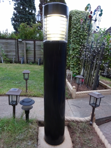 Mercury Newlec bollard, test run
For the longest time, my winter garden lighting has consisted of a SOX lantern mounted on the house, and a SON bollard light mounted in front of my main collection shed at the far end of the garden. This now left a large dark'ish patch between both of those lights, hence my search for a MBF bollard began. 

I was given this bollard by a fellow collector, its brand new and did run 70w SON-I, however since its still a rather common light, I decided to convert it to mercury. I used as close to brand new control gear as I could, and gave it a respray to freshen it up and add better protection to the paintwork. I poured a concrete bed, before drilling the slab to allow the cable to pass through, and then stuck the slab into place with more (and this time very damp) concrete. After, I secured the base to the slab, sealed just about everything I could, and wired it all into place. The wiring was all installed long ago, and much like the SON bollard I've taken the opportunity to install a manual override to allow me to demonstrate lamps with ease on correct control gear.

At night, it lights the area brilliantly well, overall its been well worth installing.

