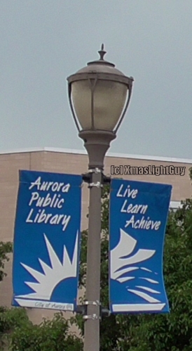 StreetLight #339
 Fairly nice looking post-top type fixture. I've seen other similar ones, generally in black.
Most I've seen have been HPS/SON, but MH does exist.. ton't know what type of lamp since I didn't see these lit.


Location:
Aurora Municipal Center/Aurora Public Library, Aurora, CO

