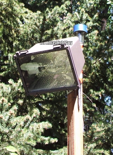  Ark Lighting 100w MH Flood 
Fitting I got at a thrift store for $10 a few years back... and eventually mounted on a pole out in the yard. (this is only occasionally used though)

The thing behind it is one of those little solar LED lights.

I'm considering converting this to MV, because its almost too bright (plus I have the extra MV lamp sitting around) 

