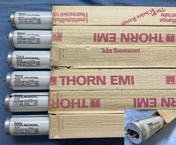 Thorn 40W Deluxe Warm White I.R.S. 4ft T12 ignition metal striped fluorescent tubes
I had mentioned in the comments of a [url=https://www.lighting-gallery.net/gallery/displayimage.php?pos=-263867]previous upload of mine[/url] that there was a lamp wholesaler which I had visited previously that had some Thorn IRS tubes on the shelf, which I figured I should go back for so as there where these tubes and some others I wanted ((to rummage through all the 8ft tubes I had to leave behind previously) I made arrangements and went back to that wholesaler to have another look at these tubes  and well I am glad I did, I had a closer look and saw they where not just Thorn IRS tubes, but in Deluxe Warm White too! so I of course had to have the lot, could not let those get bought and used by some random punter!, I also may have purchased way too many other lamps again like my previous visit, but those will be an upload later in time (I still have many lamps and tubes from my first visit to upload!)

Thorn IRS (Internal Resistance Start) tubes are equivalent to  Philips TL-M tubes, which is to say, they are Rapid-start specification tubes (3.6V low resistance cathodes) with the addition of an externally applied conductive stripe that is electrically connected to one of the tube pins via high ohmic resistor usually in the order of 1M-2M ohms (I measure just under 1M for these tubes) a picture of the setup can be [url=https://www.lighting-gallery.net/gallery/displayimage.php?pos=-258714]seen here[/url]

this arrangement has the same sort of effect that the ignition probe in a mercury lamp in helping the lamp strike, especially when there is no earthed metal work near by that is normally required by RS tubes on RS control gear

of note in the inset photo of the lamp cap is the punch-lock indented in the end cap above one of the pins, that connects the resistor from the tube pin its connected to, to the lamp cap shell which then has the stripe painted on it going the length of the tube, thats one of the fun things about these IRS/TL-M type tubes is every manufacture has a different way of doing this resistor setup :) also along those lines (pun not intended!) the starter stripe, its composition/construction can often vary, I have heard that these striped tubes where a bit of a pain for manufactures, with problems of making a stripe that could be easily/inexpensively applied to the tube during production, which was also durable well bonded to the tube

it should be noted on the subject of the stripe, that another classification of very similar looking striped tube exists the British MCFA tube also known as the TL-A tube, here the tube has the same sort of stripe, but it is *not* connected internally, and instead the stripe must be connected to earth/ground and then it performs the same function of an ignition aid for when the tube is used on starterless control gear, MCFA/TL-A tubes also have 9V high resistance cathodes, and because of this difference in cathode voltage/resistance the 2 must not be interchanged when Quickstart or Rapid-start control gear is concerned, IRS/TL-M/RS tubes are for Rapid-start circuits only and MCFE/MCFA/TL-A are for Quickstart circuits only (but the types can be interchanged on SRS control gear and Switch Start control gear)


I have not had a chance to light one of these, but I notice through the rather thin phosphor coating at the other end they are interestingly equipped with cathode guards, and I do look forward lighting them eventually being Deluxe Warm White, I am of course quite interested to look at their spectrum and see how they compare to other Warm White Deluxe type tubes like Philips Colour 32 :) (although sadly I dont currently have any other WWX tubes to compare with other than a couple Philips Colour 32 tubes in my collection, I would certainly not mind getting some WWX tubes from Osram-GEC and the USA to compare with as well) speaking of the fine details I also note the sleeves curiously do have the colour of the tubes marked on them, this is pretty unusual for Thorn, normally their sleeves are almost completely generic and betray no information about what the actual tube contained with is!
