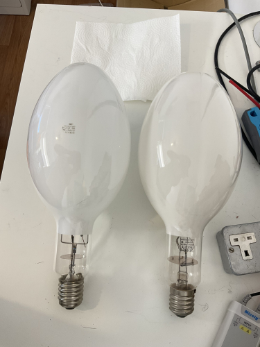 1000W Osram GEC Shaw MBF (HQL) Mercury vapour lamps 20 years apart
I have showcased the GEC lamp before in my Gallery

but recently I spotted a much more modern Osram 1Kw lamp on ebay, and all was shown was its wrapper but it was cheap enough that I figured id take a punt

secretly hoping it would be a 400V lamp as I very much want to add one of those to my collection!

sadly it was not, but it was still a very interesting lamp in that is a very late Shaw made lamp, from May 1998 (Shaw closed in Y2K) date code o858

so it made for a very interesting comparison with my GEC lamp which was made in the same factory 20 years earlier!

they both have the same frame construction, but the Osram of Germany lamp has a more pointy bulb with a shallower frame support dimple than the GEC lamp

the Osram of Germany lamp also has a more modern form of cap attachment, although the cap itself looks older than the GEC lamp which has a rather modern looking angular cap

it is also worth noting that despite them both being Yttrium Vanadate (/DX in US terms) lamps, that the older GEC lamp does have a slight warmer colour to its phosphor which I find quite interesting!

they are the same length (although it was hard to photograph them without one always looking longer than the other!) 

it also interesting to note the "7.5A" in the later Osram lamps order code, which is clearly to indicate this is a high current "low" voltage lamp

which makes me wonder if Osram of Germany, after taking over GEC, continued to make high voltage 1Kw mercury lamps? I cant say I have ever seen one but it would be interesting to know!

(it would be interesting to know who else in Europe/the UK made high voltage 1Kw mercury lamps in general, I know GEC and Thorn did, but I cant recall anyone else who might of?)

I hope you have enjoyed this comparison, and how its fun to see how 2 rather identical lamps on the surface can yield so many small interested detailed differences :) 


