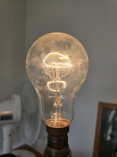 Omega 150W? Incandescent bulb 
Can't see the etch clearly as it is very worn off but could see Omega and the wattage is 150W by seeing the filament style 
