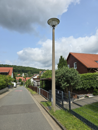A more modern drum shaped posttop streetlight 
The design looks like an updated version of those classic MV posttop drum shaped open fixtures seen at the narrow gauge railway platforms 
