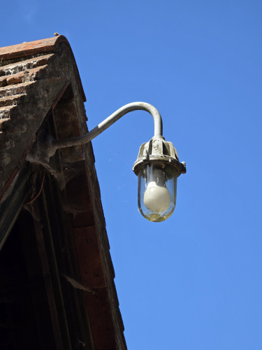 Incandescent bell jar or half capsule outdoor lantern 
At the outer porch entrance of a church not far from me and it is located on a historical site

It has got LED bulb in it 
