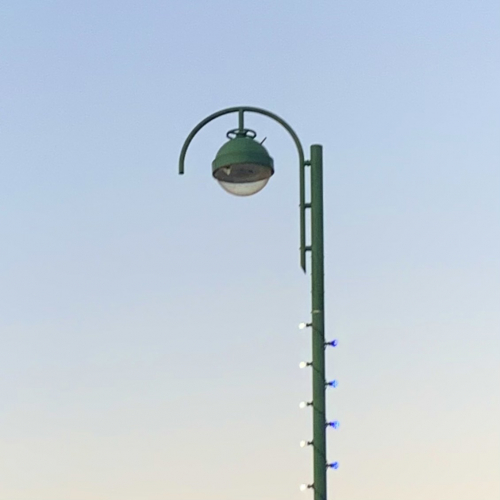Urbis Saturn
Spotted on a high street. This lantern features a cradle above the canopy for top-entry mounting. They’re pretty oversized lanterns, but they suit these columns and this mounting height perfectly. This is running 140w Cosmo.
