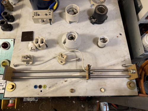 R7s test jig
Here you can see my R7s test jig. It is made from one holder on each side made of paxolin that holds two 10mm stainless steel bars. There is a paxolin slider that can be fixed by a screw. 

I hade made a simialr one for fluorescent, but it was to flimsy and unstable and so it was ultimately scrapped. However i am nu Building a new one for uorescents with a solar profile as base. 
