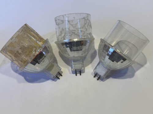 mid 2000's Paulmann MR16 halogen lamps with decorative cylinders
In the 1990s and 2000s MR16 grew an increasing popularity from display lamps to general lighting applications in domestic settings. Dichroic reflectors allowed cool beams while the lamps could be used open and the light escaping by the back used for decorative application. Dichroic coatings also allowed to design lamps with desired colour temperatures like Osram's decostar cool blue or lamps sold under the Solux brand in specific light colours like 4100K or 3500K.

Major manufacturers only had a limited portfolio of these lamps with even coloured lamps being rare. Reason being high costs for these lamps. 

Paulmann of germany was a company who arguably had in the 2000´s the biggest portfolio of 12V reflector halogen lamps, even thu these lamps hade problems. For example lamps with coloured bodies, however an organic lacker was used that degraded. Rectangular and hexagonal lamps. And also the examples shown here. 
They are intended to pimp your ceilings spots with decorative glass cylinders. They consist of standard MR16 halogen lamp without dichroic reflector in order to prevent excessive heating of the ceiling, were instead of the front lense a decorative cylinder is glued. As capsule an UV stopping quartz capsule is used. It is believed that the capsule also have a low pressure filling in order to lower the risk of shatter of the capsule in an open lamp. 

This concept however was not new. The first lamps with decorative cylinders and textured lenses were first introduce by GE-Thorn in 1990-1991. 

Who manufactured these lamps is not known. To my understanding Paulmann was and for the fact still is a reseller in the lighting industry that specialises in decorative lighting. I am certain that these lamps were not made by paulmann themselves. I however also doubt that these lamps come from china. It may be that these lamps were made by bLV but that is nothing more but a guess. 
