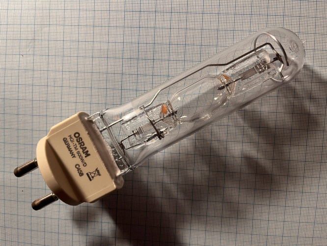 OSRAM HQI-TM 600W
As a follow up to this [url=http://80.229.24.59:9232/gallery/displayimage.php?album=lastup&cat=0&pid=23175#top_display_media]400W ceramic metal halide lamp[/url] in a very compact formfactor I decided to get the even higher power quartz variety. This time in the 600W/D (Daylight) variety. Apart from this a bigger 1000W variety was also offered.
The idea of this lamp design was described in the post linked above. I will just go into this particular design.
As well as the smaller -TM lamps this lamp was also made in the Radium Wipperfürth plant in Germany.

The Lamp is made in a tubular 34mm white quartz tube employing a special doping blocking UV radiation.
In this quartz tube a quartz discharge vessel is located having an approx. 30mm long arc length.

I tried figuring out the halide chemistry of this lamp. Clearly seen can be seen red halides arounds the top and bottom electrodes. It’s not the first time I see red halides in a lamp, but you do not see them every day. Anyway I believe that these red halides are tin iodine.
Thats however already all of my tries of identifying the chemistry lamps. I believe that these lamps also contain dysprosium and caesium iodine like other other Osram rare earth daylight metal halide lamps but that is absolute speculation.
I believe this lamp lamp contains argon as a buffer gas. Krypton 85 was used before 2010 when regulation regarding the air transport of radioactive materials. As a new ignition aid a small capacitive uv sources is used which may be seen here. This UV sources help with ignition by facilitation of ionization of the gas in the arc tube.
The lamps light centre is located at the same hight as all the other -TM lamps, allowing for more simple fixture design.
The high power lamps seem to be a bit more popular than the low power CMH lamps. These were often used in big compact spotlights in architectural but also for sport lighting and spotlighting in industrial facilities. However the complete TM lamp series was discontinued in 2014/2015.
